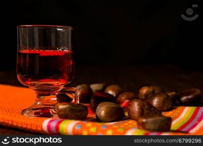 Alcoholic punch drink and chestnuts over a colored napkin. Alcoholic punch drink and chestnuts