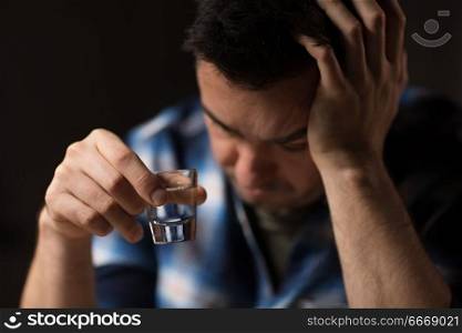 alcoholism, alcohol addiction and people concept - close up of male alcoholic drinking vodka shot at night. close up of man drinking alcohol or vodka at night. close up of man drinking alcohol or vodka at night