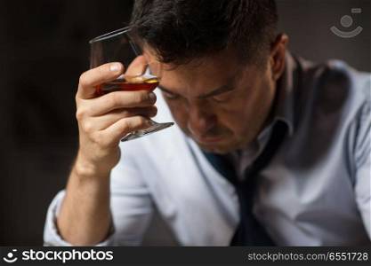alcoholism, alcohol addiction and people concept - close up of male alcoholic drinking brandy at night. close up of drunk man drinking alcohol at night. close up of drunk man drinking alcohol at night