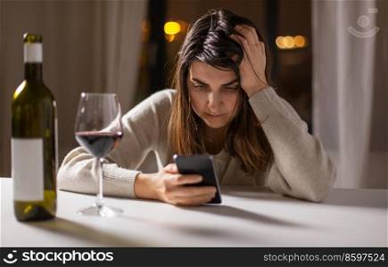 alcoholism, alcohol addiction and people concept - drunk woman or female alcoholic with smartphone drinking red wine at home. woman alcoholic with phone drinking wine at home