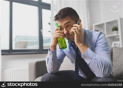 alcoholism, alcohol addiction and people concept - male alcoholic drinking beer and calling on smartphone at home. man with bottle of alcohol calling on smartphone. man with bottle of alcohol calling on smartphone
