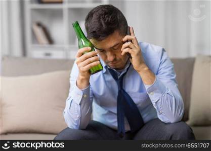 alcoholism, alcohol addiction and people concept - male alcoholic drinking beer and calling on smartphone at home. man drinking alcohol and calling on smartphone. man drinking alcohol and calling on smartphone