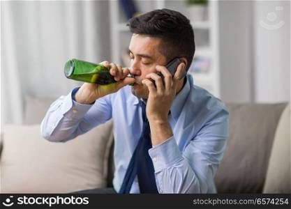 alcoholism, alcohol addiction and people concept - male alcoholic drinking beer and calling on smartphone at home. man drinking alcohol and calling on smartphone