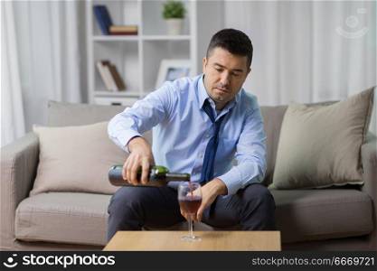 alcoholism, alcohol addiction and people concept - male alcoholic pouring red wine to glass at home. alcoholic pouring red wine to glass at home. alcoholic pouring red wine to glass at home