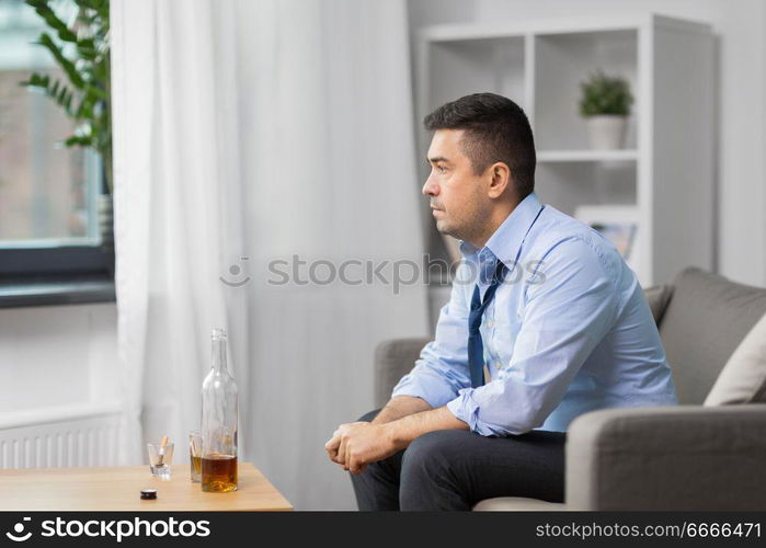 alcoholism, alcohol addiction and people concept - male alcoholic with bottle of whiskey at home. alcoholic with bottle drinking whiskey at home. alcoholic with bottle drinking whiskey at home