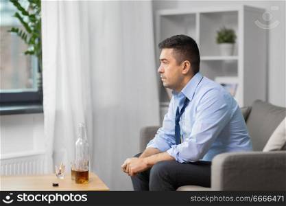 alcoholism, alcohol addiction and people concept - male alcoholic with bottle of whiskey at home. alcoholic with bottle drinking whiskey at home. alcoholic with bottle drinking whiskey at home