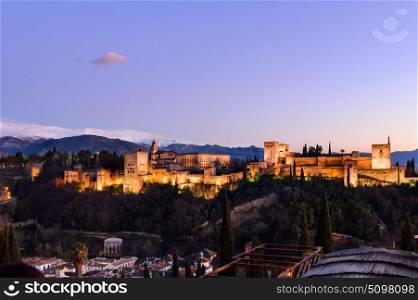 Alhambra fortress night view. Alhambra fortress night view against Sierra Nevada mountains, Granada, Spain