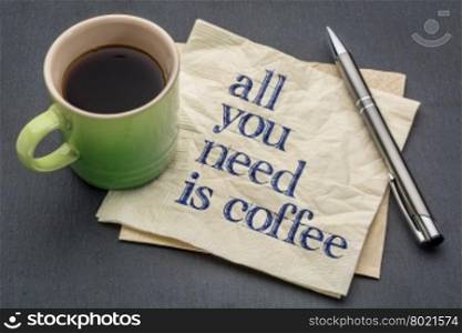 All you need is coffee - handwriting on a napkin with cup of coffee against gray slate stone background