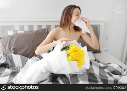 Allergy medical seasonal flowers concept. Woman with napkin fighting blossom allergy on bed at home. Allergy to flowers. Young woman is going to sneeze. Sneezing and runny nose from pollen.. Allergy medical seasonal flowers concept. Woman with napkin fighting blossom allergy on bed at home. Allergy to flowers. Young woman is going to sneeze. Sneezing and runny nose from pollen