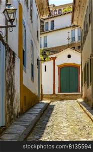 Alley with old houses and chapel in the background in the city of Ouro Preto in the state of Minas Gerais, Brazil. Alley with old houses and chapel in the background 