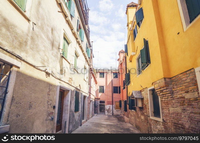 Alley with worn buildings of bricks and concrete in Venice Italy in beautiful colors