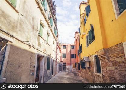 Alley with worn buildings of bricks and concrete in Venice Italy in beautiful colors