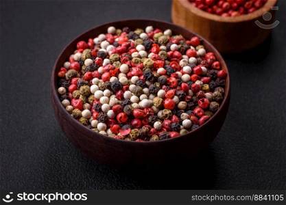 Allspice peas in a wooden bowl on a black concrete background. Preparing spices for cooking at home