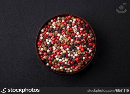 Allspice peas in a wooden bowl on a black concrete background. Preparing spices for cooking at home