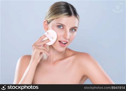 Alluring beautiful female model applying powder puff for facial makeup concept. Portrait of flawless perfect cosmetic skin woman put powder foundation on her face in isolated background.. Alluring beautiful female model applying powder puff for facial makeup concept.