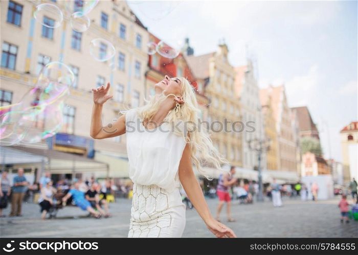 Alluring blond lady having a grat fun with the soap bubbles