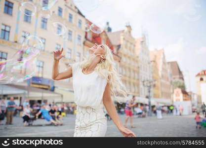 Alluring blond lady having a grat fun with the soap bubbles