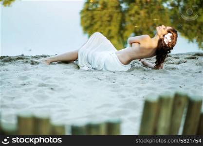 Alluring lady lying on the white sand