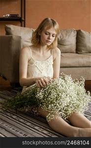alluring woman posing sofa while holding bouquet delicate spring flowers