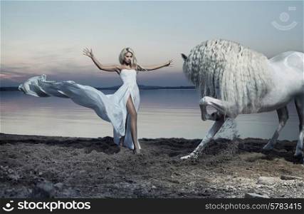 Alluring woman taming the white horse