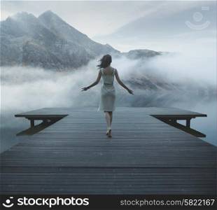 Alluring woman walking on the wooden jetty
