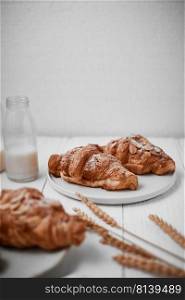 Almond croissant with custard filling on wood background.