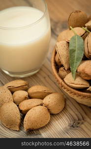 Almond milk with almonds on a wooden table and focus with shallow depth of field