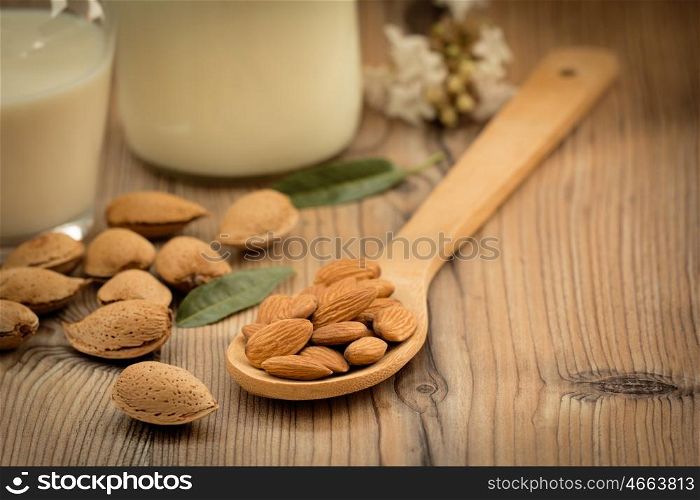 Almond milk with almonds on a wooden table and focus with shallow depth of field