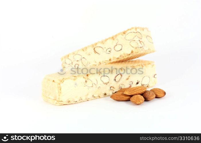 Almond nougat with some almonds, isolated on white