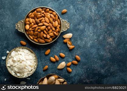 Almond nuts on dark background directly above copy space flat lay