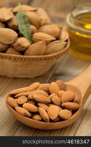 Almond oil and almonds on an old wooden background, selective focus