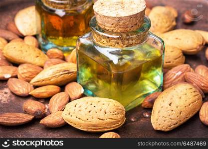Almond oil in bottle and nuts. Almond oil in glass bottle and almonds