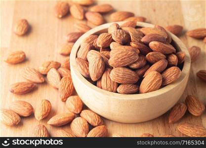 Almond seeds in a bowl wood on table wooden brown