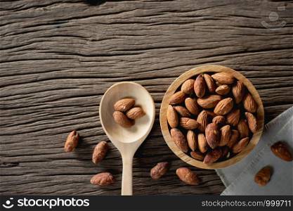 Almonds, baked salt in the cup. Placed on an old wood table.