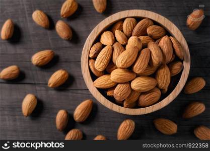almonds in bowl wood on dark table background