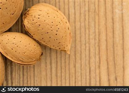 Almonds on brown wooden background