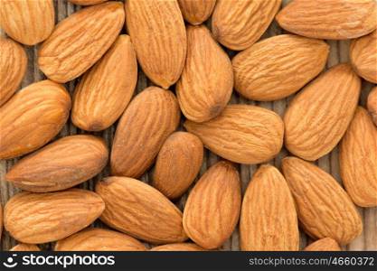 Almonds on brown wooden background