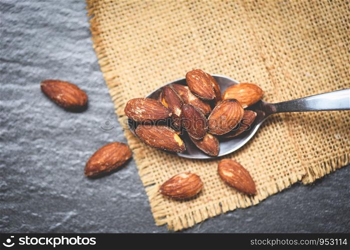 Almonds roasted in a spoon on sack , close up almonds nuts baked salt