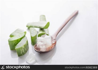 aloe vera gel on wooden spoon with aloe vera on white background,aloe vera is tropical green plants.Sliced Aloe Vera natural organic renewal cosmetics, alternative medicine. Organic Skin care concept.