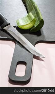 Aloe vera slices on dark board. Health and beauty concept. Closeup aloe cut leaf on backlight.