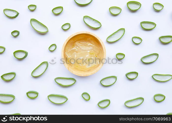 Aloe vera slices with aloe vera gel in wooden bowl on white background.