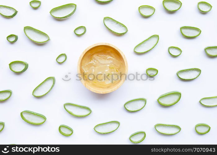 Aloe vera slices with aloe vera gel in wooden bowl on white background.