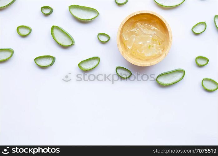 Aloe vera slices with aloe vera gel in wooden bowl on white background.