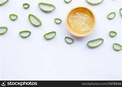 Aloe vera slices with aloe vera gel in wooden bowl on white background.
