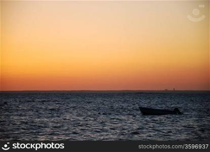Alone boat in sunset.