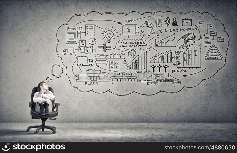Alone in his ideas. Young depressed businessman sitting in chair isolated from world