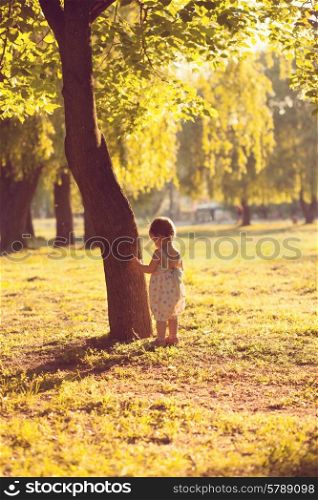 alone toddler playing near the tree
