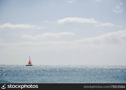 Alone yacht with colorful sail in glittering water by the coast of Gran Canaria at the Canary Islands in Spain