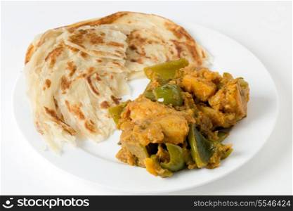 Aloo capsicum, potato and bell pepper vegetarian curry, served with paratha fried flatbread in the traditional way.