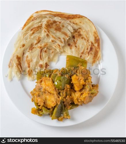 Aloo capsicum, potato and bell pepper vegetarian curry, served with paratha fried flatbread in the traditional way, viewed from above
